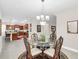 Dining room featuring glass table, chandelier, and view into kitchen at 1545 Caterpillar St, St Cloud, FL 34771