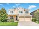 Two-story home featuring a two-car garage, manicured lawn, and a light beige color scheme at 1545 Caterpillar St, St Cloud, FL 34771