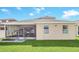 Rear view of the home shows screened lanai and well-maintained lawn for outdoor enjoyment and relaxation at 1545 Caterpillar St, St Cloud, FL 34771