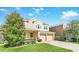 Tan two-story home featuring manicured lawn, two-car garage and traditional architectural details at 1545 Caterpillar St, St Cloud, FL 34771