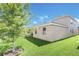 Side view of home with a lush green lawn, showcasing the well-kept landscaping and exterior features at 1545 Caterpillar St, St Cloud, FL 34771