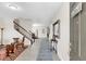 Inviting home foyer with a staircase, neutral walls, tile flooring, and a decorative mirror at 1545 Caterpillar St, St Cloud, FL 34771
