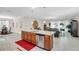 Spacious kitchen with stainless steel appliances, granite countertops, and center island that leads to the living room at 1545 Caterpillar St, St Cloud, FL 34771