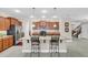 Stylish kitchen featuring stainless steel appliances, granite countertops, a breakfast bar, and a view of the staircase at 1545 Caterpillar St, St Cloud, FL 34771
