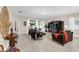 Inviting living room with large windows, tiled floors, comfortable seating, and seamless access to the outdoor area at 1545 Caterpillar St, St Cloud, FL 34771