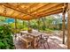 Charming backyard patio with a wooden table and chairs under a pergola with string lights at 1624 Park Lake St, Orlando, FL 32803