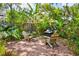Serene backyard with a brick patio, Adirondack chairs, and lush tropical landscaping surrounding a firepit at 1624 Park Lake St, Orlando, FL 32803