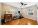 Bedroom featuring hardwood floors, ceiling fan, and natural light from dual windows, alongside fitness equipment at 1624 Park Lake St, Orlando, FL 32803