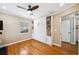 Bright bedroom with hardwood floors, ceiling fan, and built-in murphy bed with shelving and cabinets at 1624 Park Lake St, Orlando, FL 32803