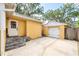 Charming yellow home with a white door and a detached garage accessible by stone steps at 1624 Park Lake St, Orlando, FL 32803