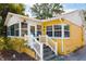 Quaint yellow home featuring stone steps with white railing and a sunroom, blending classic charm with modern updates at 1624 Park Lake St, Orlando, FL 32803