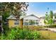 Charming yellow home featuring a white roof, number display, and manicured landscaping for enhanced curb appeal at 1624 Park Lake St, Orlando, FL 32803