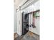 Efficient laundry room featuring stacked washer and dryer and a barn-style door with shelving at 1624 Park Lake St, Orlando, FL 32803
