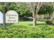 Colonial Town Square sign, lush greenery, and a quaint glimpse of homes create a welcoming community entrance at 1624 Park Lake St, Orlando, FL 32803