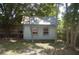 Backyard shed with metal roof surrounded by trees and grass, with an access door and two windows at 1644 Cypress Woods Cir, St Cloud, FL 34772