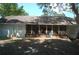 Home featuring a rear screened-in porch, a well-maintained yard, and a connection to the surrounding landscape at 1644 Cypress Woods Cir, St Cloud, FL 34772
