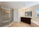 Clean bathroom featuring a walk-in shower with glass door, soaking tub, and vanity with a large mirror at 16500 Cedar Run Dr, Orlando, FL 32828