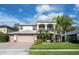 Charming two-story home featuring a brick driveway, lush landscaping, and a second-floor balcony at 16500 Cedar Run Dr, Orlando, FL 32828