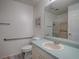 Well-lit bathroom features a walk-in shower, grab bars, and updated vanity with a light blue countertop at 1707 E Schwartz Blvd, Lady Lake, FL 32159