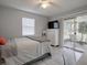 Bright bedroom with ceiling fan, large window with blinds, and a screened-in porch at 1707 E Schwartz Blvd, Lady Lake, FL 32159