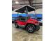 New red Advanced EV golf cart with black seats and a roof, parked inside a showroom at 1707 E Schwartz Blvd, Lady Lake, FL 32159