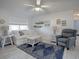 Bright living room featuring a ceiling fan, white sofa, and blue patterned rug at 1707 E Schwartz Blvd, Lady Lake, FL 32159