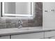 Modern bathroom sink with illuminated mirror and gray stone backsplash creates a sleek look at 1764 Mondrian Cir, Winter Park, FL 32789