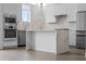 Modern, all-white kitchen with stainless steel appliances and marble countertops including the island at 1764 Mondrian Cir, Winter Park, FL 32789