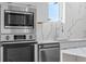Modern kitchen with stainless steel appliances, including oven, microwave, dishwasher, and quartz countertops at 1764 Mondrian Cir, Winter Park, FL 32789