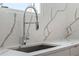 Close up of a stainless steel kitchen sink with a modern, flexible faucet and quartz countertops at 1764 Mondrian Cir, Winter Park, FL 32789