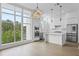 Modern, all-white kitchen featuring stainless steel appliances, marble countertops, and a large window for natural light at 1764 Mondrian Cir, Winter Park, FL 32789