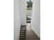 Staircase featuring wood steps, black metal railings, and natural light from a tall window at 1764 Mondrian Cir, Winter Park, FL 32789