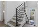 Modern staircase with wood treads, white risers, and sleek black metal railings at 1764 Mondrian Cir, Winter Park, FL 32789
