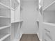 Spacious walk-in closet with custom white built-in shelving and drawers, ready for organization at 1764 Mondrian Cir, Winter Park, FL 32789