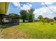 Large back yard with storage shed, green grass, and trees at 206 Montana Ave, St Cloud, FL 34769