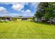 Back yard featuring expansive lawn with storage shed and distant houses at 206 Montana Ave, St Cloud, FL 34769