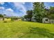 Wide shot of the expansive back yard featuring a storage shed and green grass at 206 Montana Ave, St Cloud, FL 34769