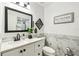 Bathroom with white marble-style tiling, updated fixtures, and modern mirror at 206 Montana Ave, St Cloud, FL 34769
