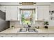Kitchen sink beneath a window, surrounded by white cabinets and a view of the outdoors at 206 Montana Ave, St Cloud, FL 34769