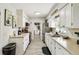 Bright kitchen featuring white cabinetry, stainless steel appliances, and light wood-look floors at 206 Montana Ave, St Cloud, FL 34769