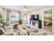 Cozy living room featuring a sectional sofa, fireplace, and open doorway to the bedroom at 206 Montana Ave, St Cloud, FL 34769