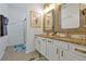 Beautiful bathroom featuring dual sinks with gold fixtures, granite countertops, and a glass shower at 2624 Daulby St, Kissimmee, FL 34747