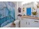 Bright bathroom with a marble countertop, white cabinets, and a stylish blue marble shower curtain at 2624 Daulby St, Kissimmee, FL 34747
