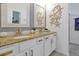 Bathroom with double sinks, white cabinets, and a starfish decoration on the wall at 2624 Daulby St, Kissimmee, FL 34747