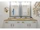 Bathroom with granite countertop, double sinks, and shell-framed mirrors at 2624 Daulby St, Kissimmee, FL 34747