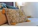 Close-up of a decorative floral pillow with tassels on a bed, adding texture and charm at 2624 Daulby St, Kissimmee, FL 34747