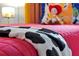 Close-up shot of a themed twin bed featuring colorful bedding, a decorative pillow, and cartoon-inspired elements at 2624 Daulby St, Kissimmee, FL 34747