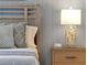 A bedroom with a light wood bed frame and matching night stand, with an interesting carved lamp at 2624 Daulby St, Kissimmee, FL 34747