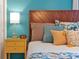Bright bedroom featuring a wooden headboard, colorful pillows, and a yellow nightstand with lamp at 2624 Daulby St, Kissimmee, FL 34747