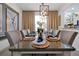 Elegant dining room featuring stylish decor, a modern light fixture, and a glass-top table set for a dinner party at 2624 Daulby St, Kissimmee, FL 34747